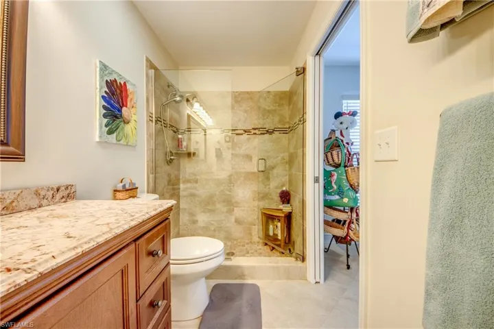 Bathroom with vanity, tiled shower, and toilet