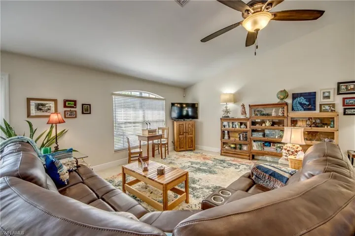 living room featuring ceiling fan and lofted ceiling