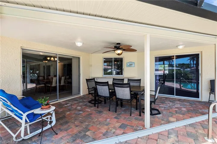 View of patio / terrace with ceiling fan and outdoor dining space  Photo virtually enhanced.