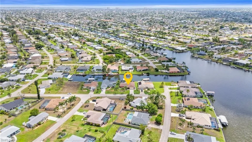 Aerial overview of property's location with nearby suburban area and a large body of water  Photo virtually enhanced.