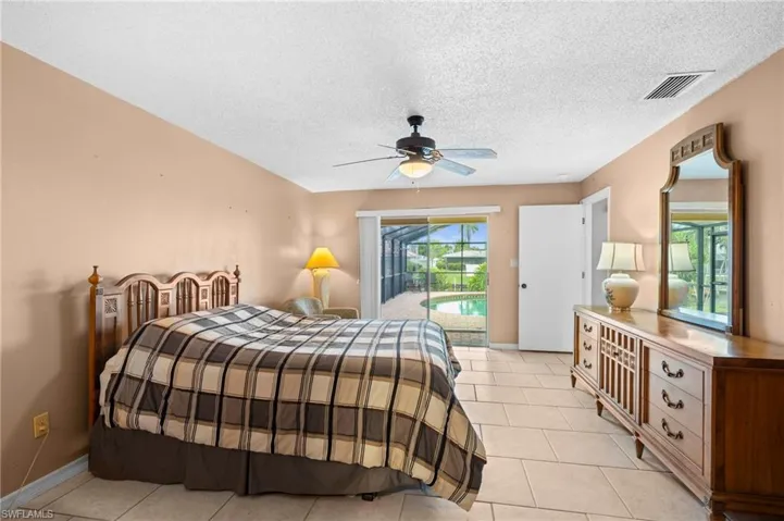 Bedroom with access to outside, light tile patterned flooring, a ceiling fan, a textured ceiling, and baseboards