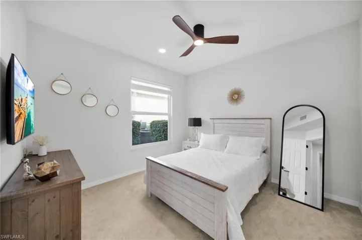 Bedroom with light carpet, ceiling fan, and recessed lighting