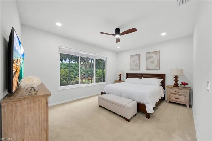 Bedroom featuring light colored carpet, ceiling fan, and recessed lighting