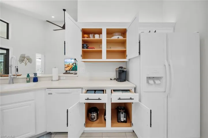 Kitchen with white cabinetry, white appliances, light countertops, and open shelves