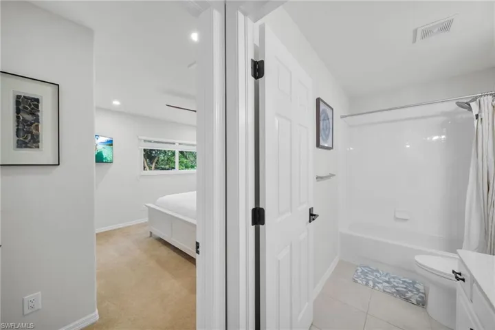 Bathroom with shower / bath combo, vanity, light tile patterned floors, recessed lighting, and light colored carpet