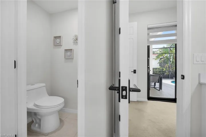 Bathroom with light tile patterned flooring and light colored carpet