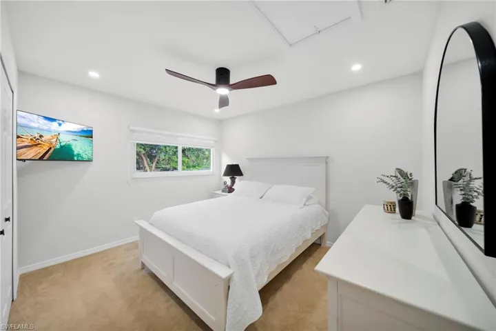 Bedroom with recessed lighting, a ceiling fan, light colored carpet, and cooling unit