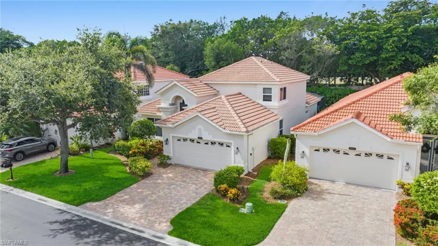 Mediterranean / spanish home featuring stucco siding, a tiled roof, driveway, an attached garage, and a front yard
