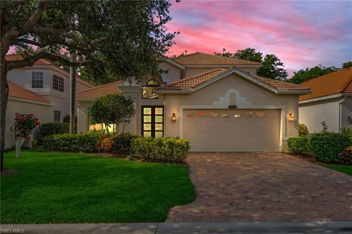 Mediterranean / spanish home featuring a tile roof, stucco siding, a lawn, and decorative driveway