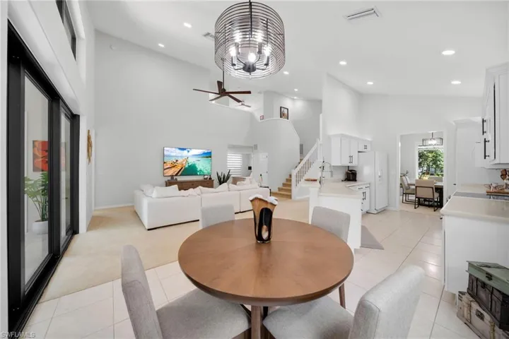 Dining area with hanging lights, a high ceiling, a ceiling fan, and light tile patterned floors