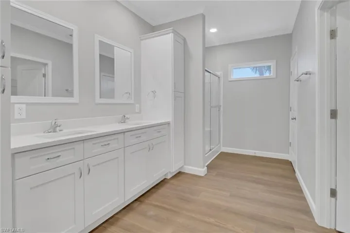 Master Bathroom featuring double vanity and an enclosed shower.