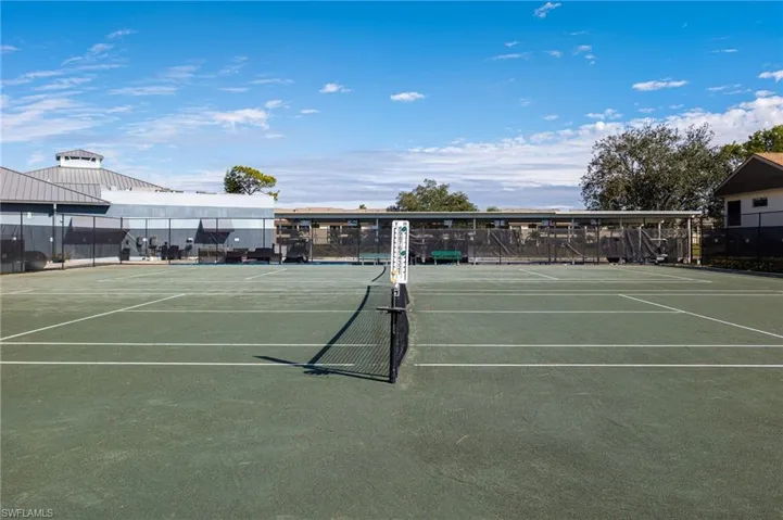 Two tennis courts featuring a green surface and white court lines