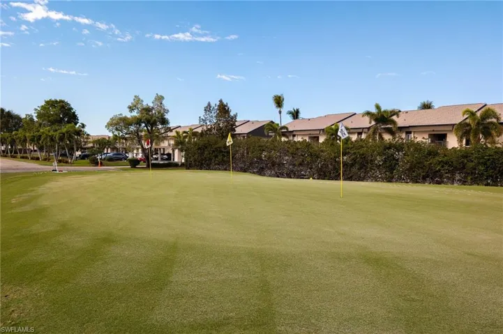 Expansive green space featuring golf flags and surrounding mature landscaping