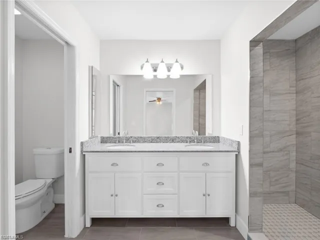 Bathroom with double vanity and tiled shower