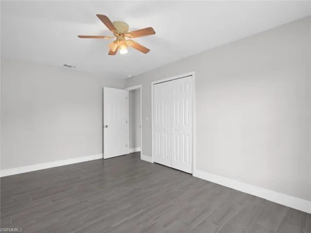 Unfurnished bedroom with a closet, a ceiling fan, and wood finished floors