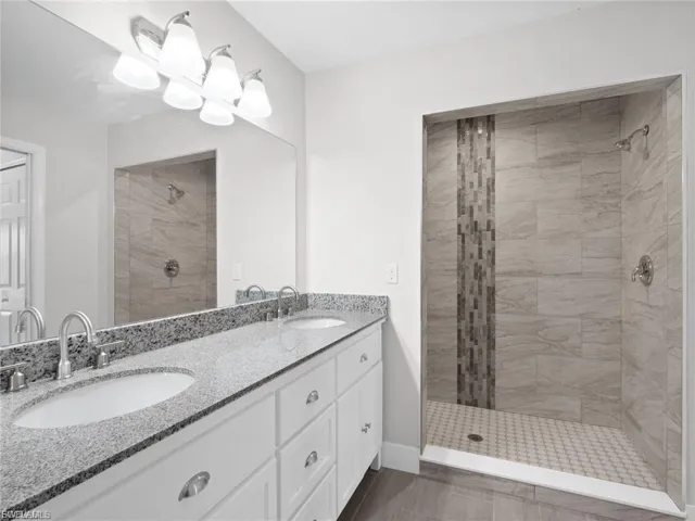 Bathroom with double vanity and a tile shower