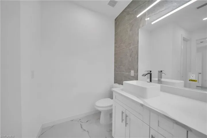 Bathroom with an expansive vanity featuring an integrated rectangular sink and polished chrome faucet