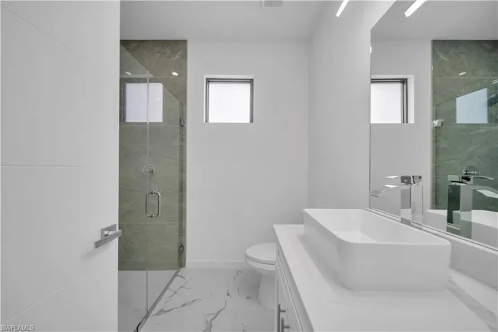 Contemporary bathroom featuring a floating vanity with a rectangular vessel sink, polished chrome faucet, and expansive mirror