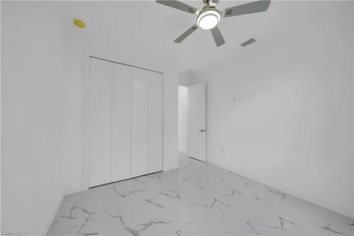 Bright interior space featuring white walls and a contemporary ceiling fan