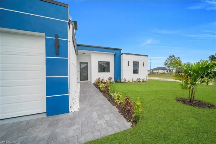 Contemporary exterior featuring a bold blue accent wall and white stucco finishes