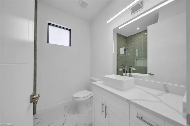 Contemporary bathroom featuring a floating white vanity with a rectangular vessel sink, polished chrome faucet, and quartz countertop