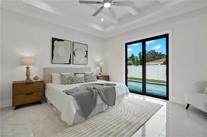 Bedroom featuring a tray ceiling, access to exterior, baseboards, recessed lighting, and marble finish floor