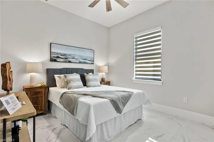 Bedroom with baseboards, a ceiling fan, and marble finish floor