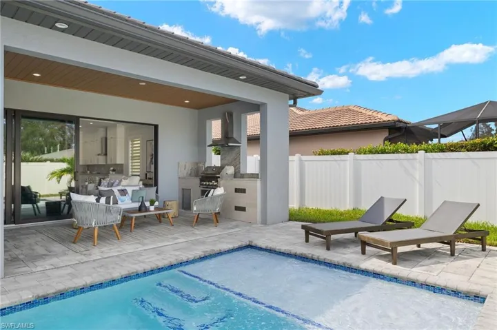 View of pool with fence, a grill, a patio, a fenced in pool, and area for grilling