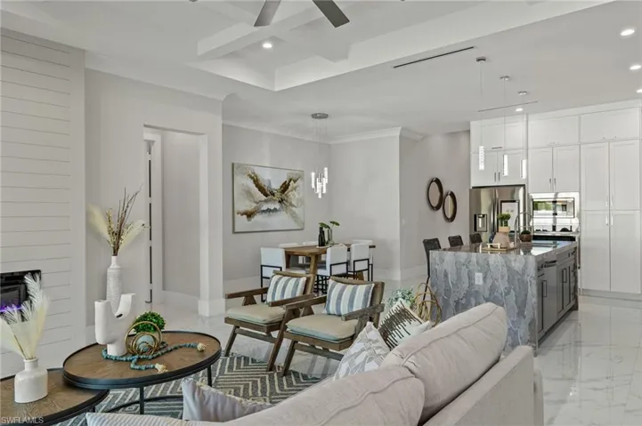 Living area with recessed lighting, coffered ceiling, beamed ceiling, baseboards, and ceiling fan