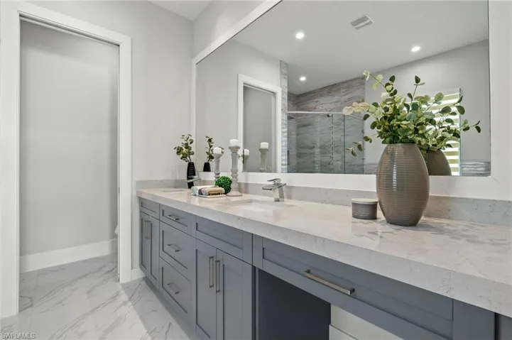 Full bath featuring recessed lighting, a shower stall, double vanity, visible vents, and a sink