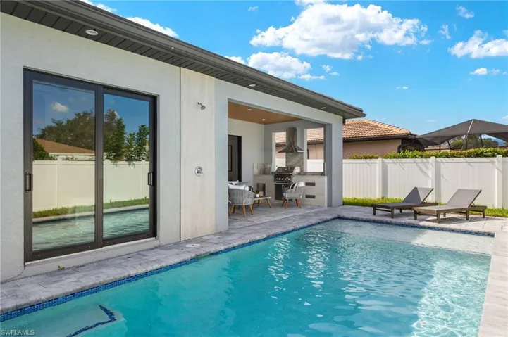 View of swimming pool featuring fence, a fenced in pool, area for grilling, and a patio