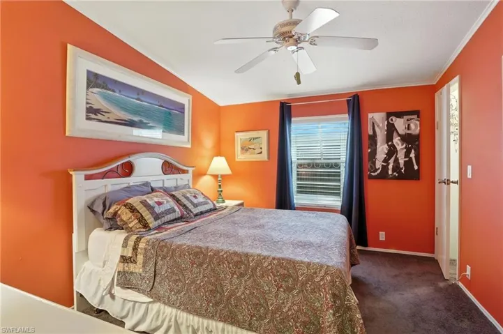 Guest Bedroom with ornamental molding, carpet, and ceiling fan