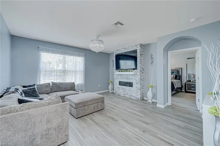 Living area featuring light wood-style floors, a fireplace, and hanging lights