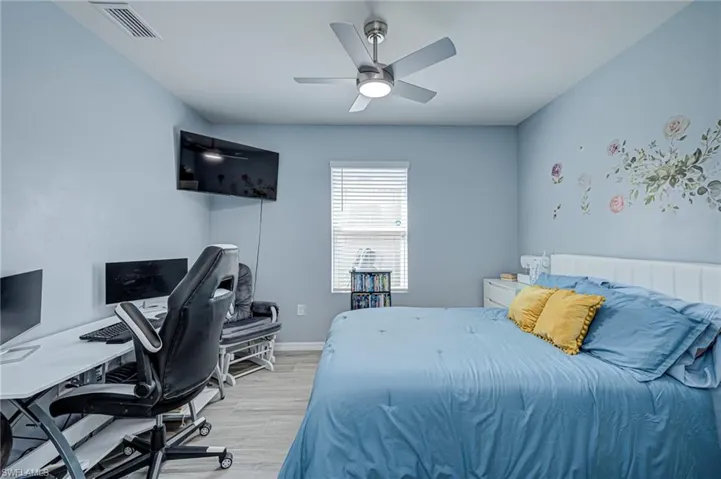 Bedroom featuring a desk, light wood-type flooring, and a ceiling fan