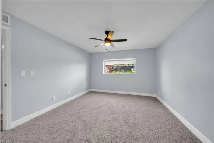 Room featuring light blue walls, gray carpeting, and white baseboards