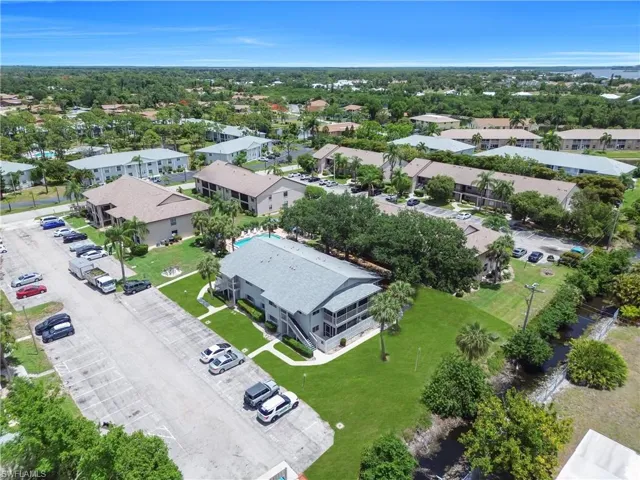 Community featuring multiple residential buildings, surface parking, and a central swimming pool