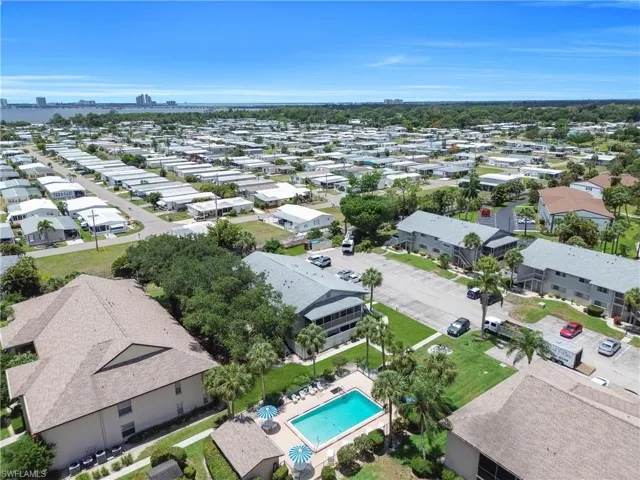 Aerial perspective showcasing a community with varied rooflines and extensive tree coverage
