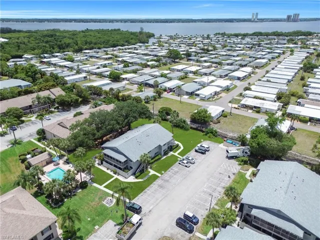 Aerial perspective showcasing a residential community with water frontage and distant skyline