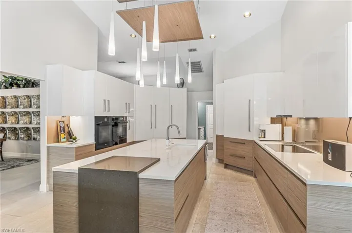 Right side Sub Zero fridge and freezer drawers Miele cook top amazing lighting over center island Miele ovens on left