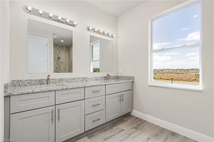 Bathroom featuring hardwood / wood-style flooring and double sink vanity. Finishes may vary, pictures for illustration purposes only