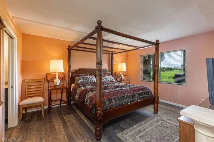 Bedroom with baseboards and dark wood-style flooring