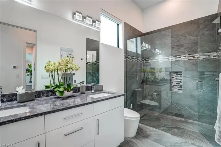 Bathroom with double vanity and a stall shower