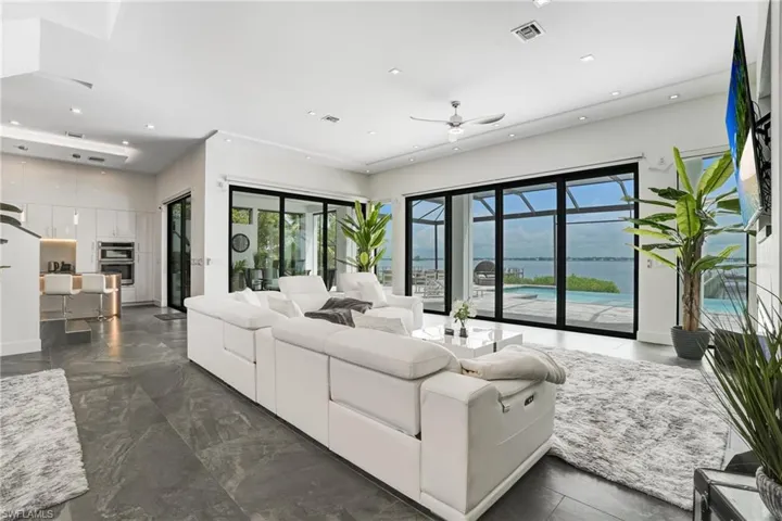 Living room featuring recessed lighting, ceiling fan, and dark marble finish floors