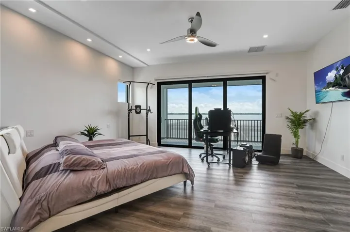 Bedroom with wood finished floors, a ceiling fan, access to exterior, and recessed lighting