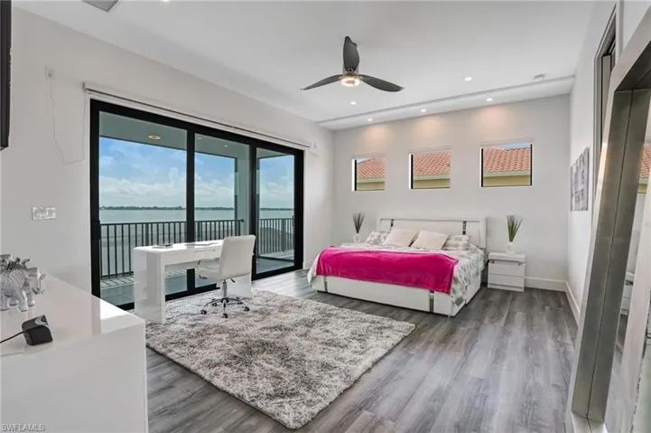 Bedroom featuring a water view, recessed lighting, access to exterior, dark wood finished floors, and ceiling fan