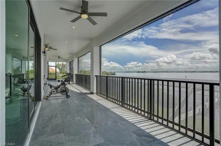 Balcony featuring a water view and ceiling fan