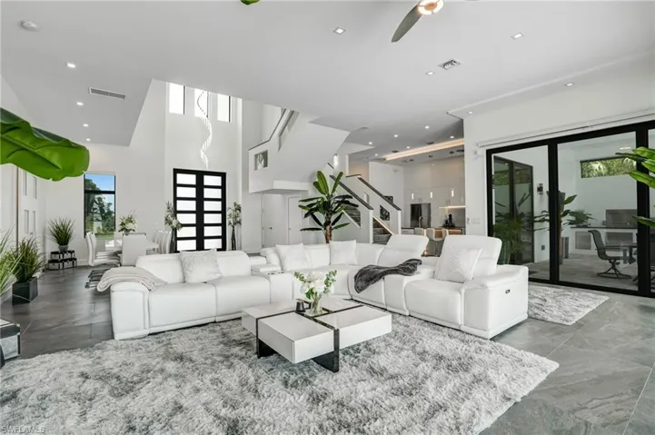 Living area featuring recessed lighting, a high ceiling, and stairway