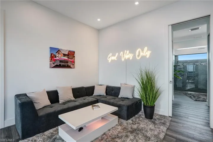Living room with dark wood-type flooring and baseboards