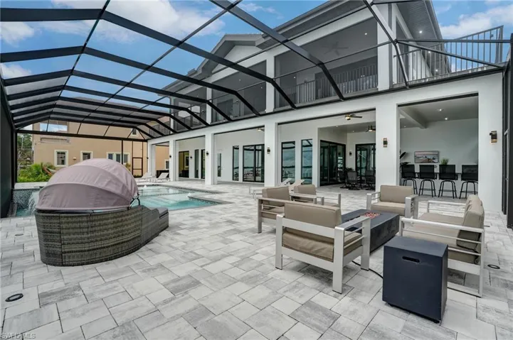 View of patio featuring an outdoor living space with a fire pit, an outdoor pool, a lanai, and a sunroom