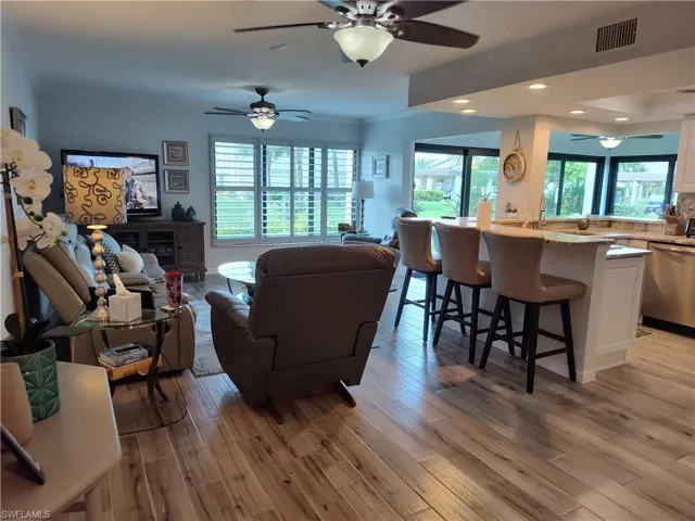Living room with ceiling fan and light hardwood / wood-style flooring